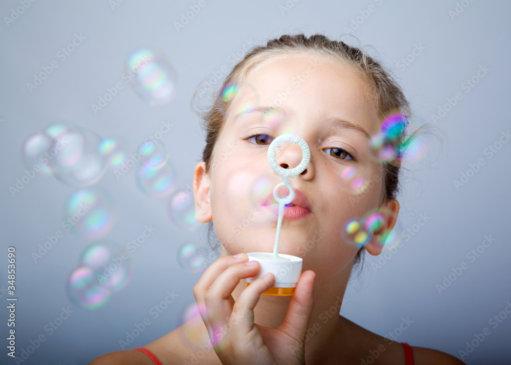 Portrait of funny lovely little girl blowing soap bubbles Portrait of funny lovely little girl blowing soap bubbles