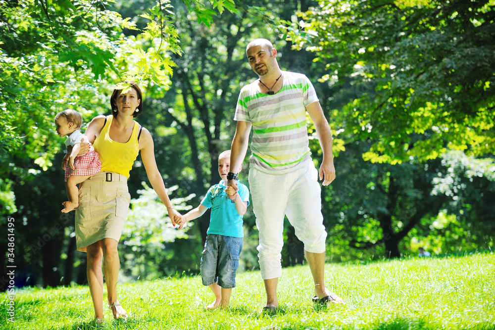 Obraz premium happy young couple with their children have fun at park