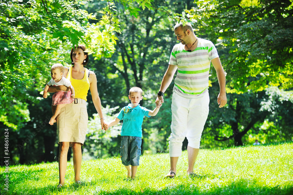 happy young couple with their children have fun at park