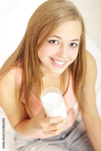 Girl with a glass of milk on a light background