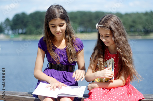 Two girls reading a book © vaitekune