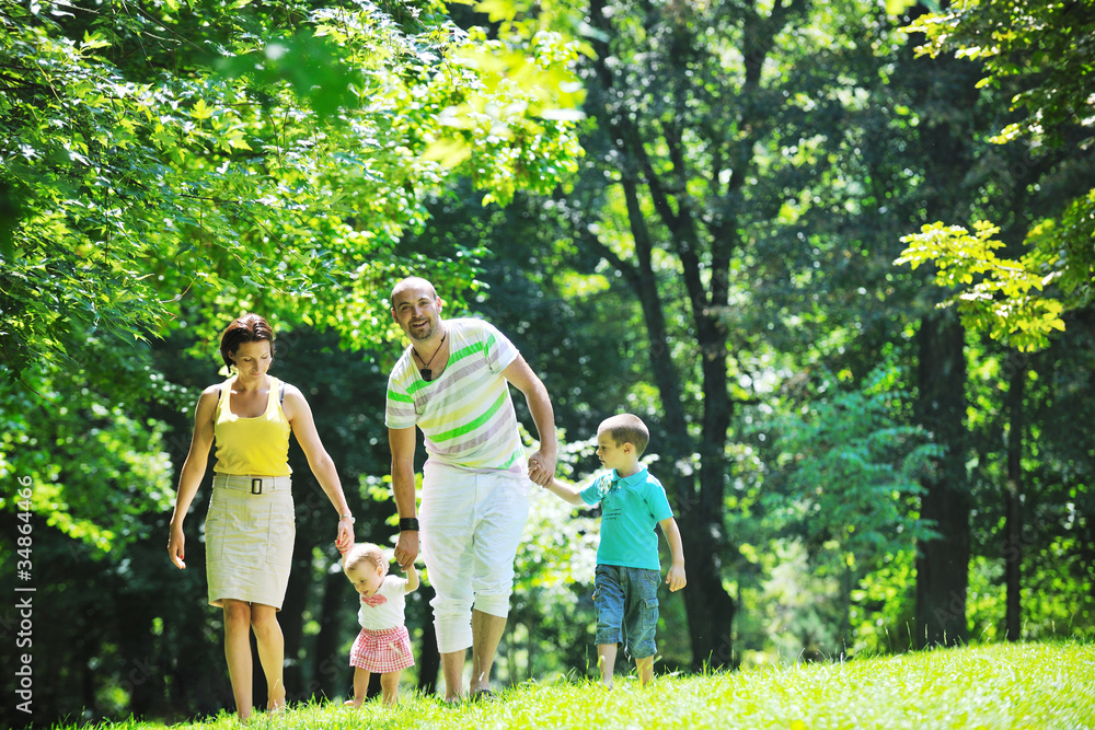 Obraz premium happy young couple with their children have fun at park
