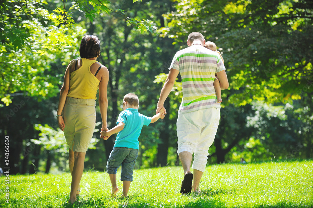 Fototapeta premium happy young couple with their children have fun at park