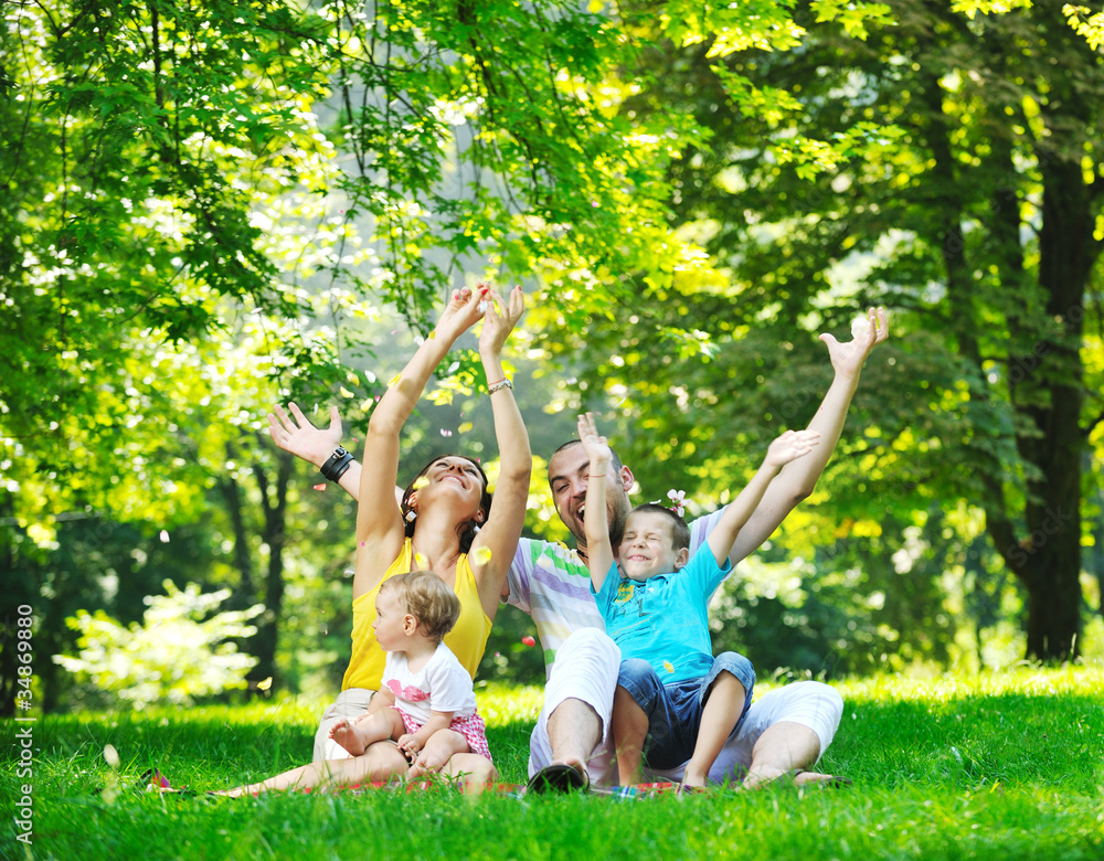Fototapeta premium happy young couple with their children have fun at park