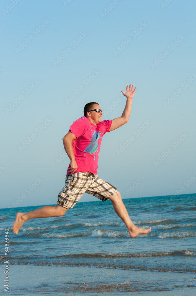 Fototapeta premium Young man jumping in the ocean