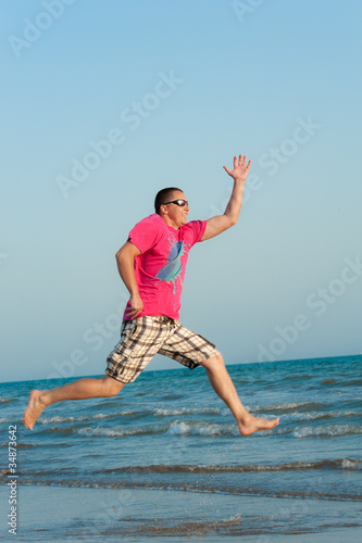 Young man jumping in the ocean