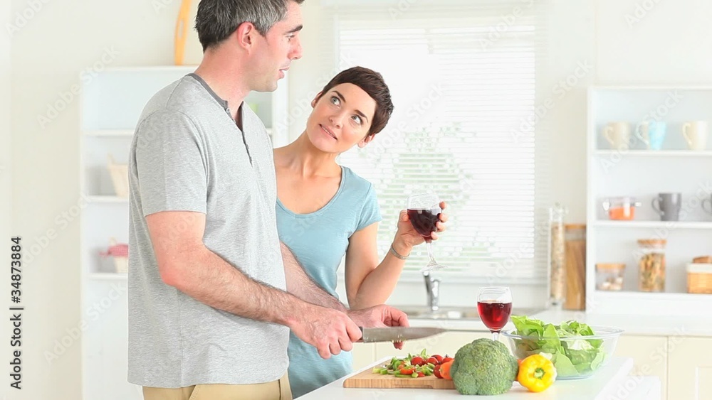 Man preparing dinner while woman is watching Man preparing dinner while woman is watching
