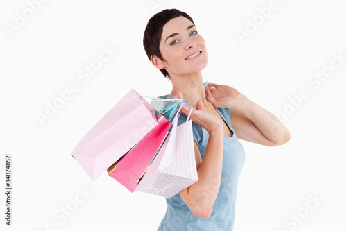 Dark-haired woman posing with shopping bags