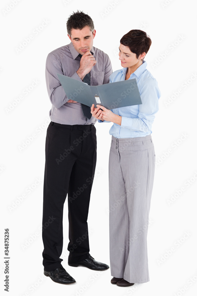 Office workers looking at a binder Office workers looking at a binder