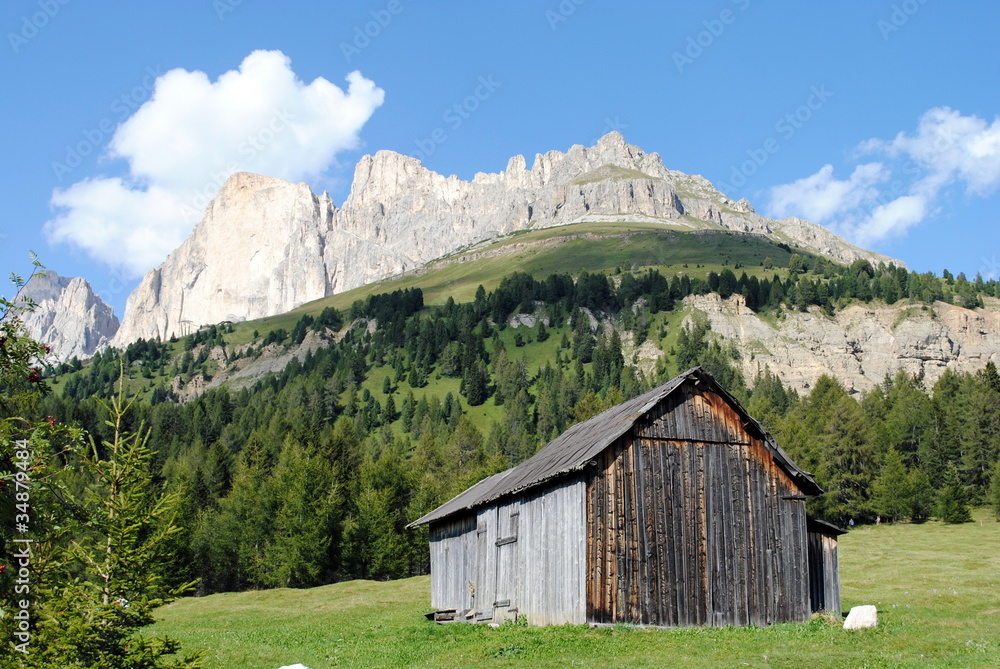 baita in legno con dolomiti sullo sfondo