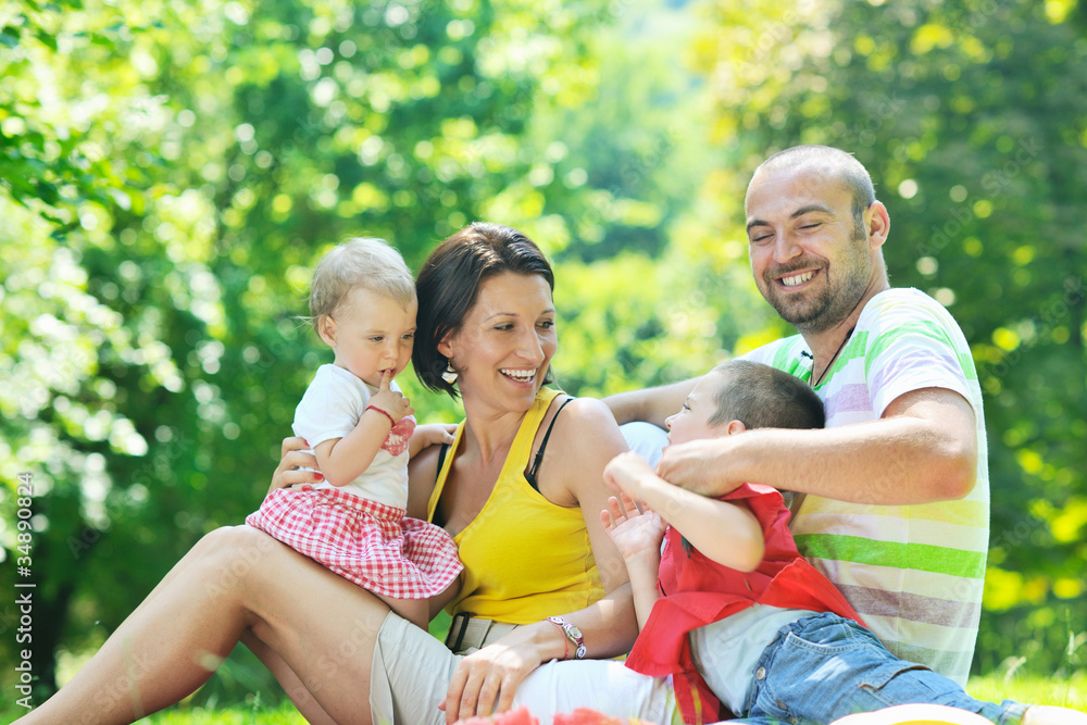 © .shock - happy young couple with their children have fun at park