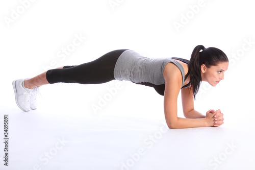 Athletic beautiful young woman exercising on floor