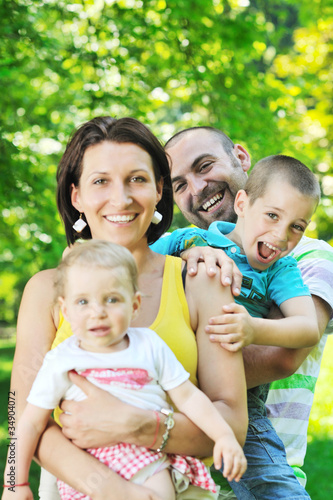 happy young couple with their children have fun at park