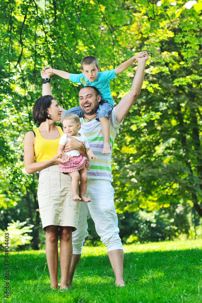 Fototapeta premium happy young couple with their children have fun at park