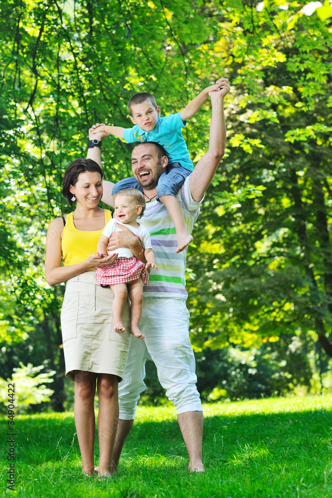 Fototapeta premium happy young couple with their children have fun at park