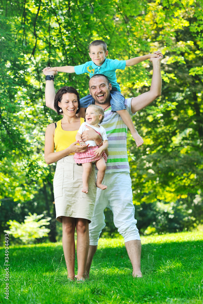 Fototapeta premium happy young couple with their children have fun at park