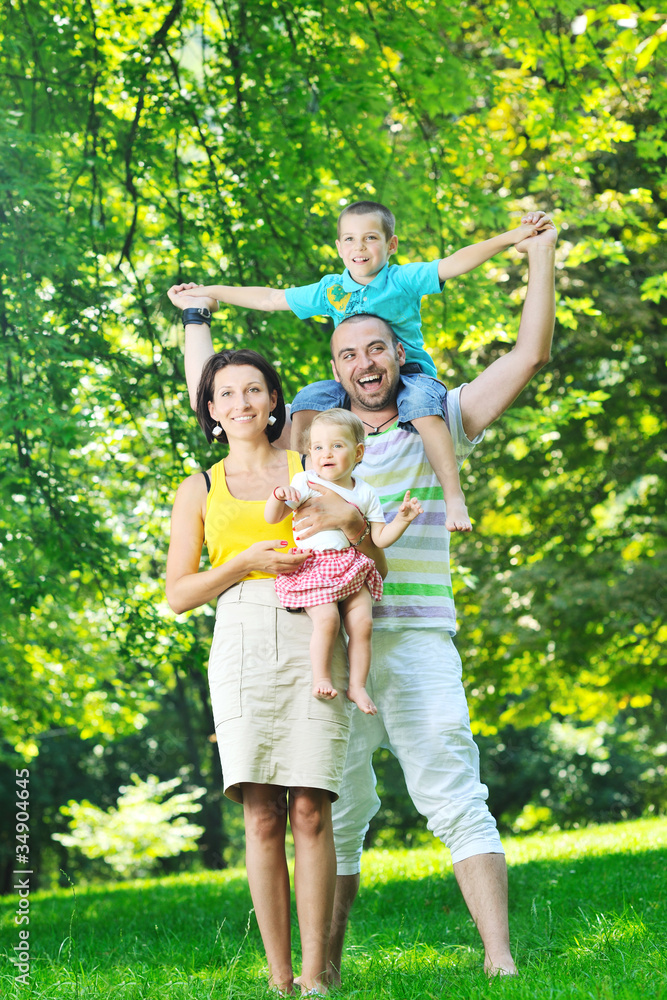 happy young couple with their children have fun at park