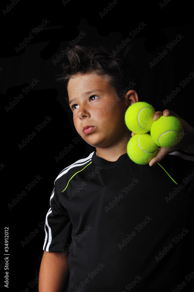Tennis boy holding balls isolated in black Tennis boy holding balls isolated in black