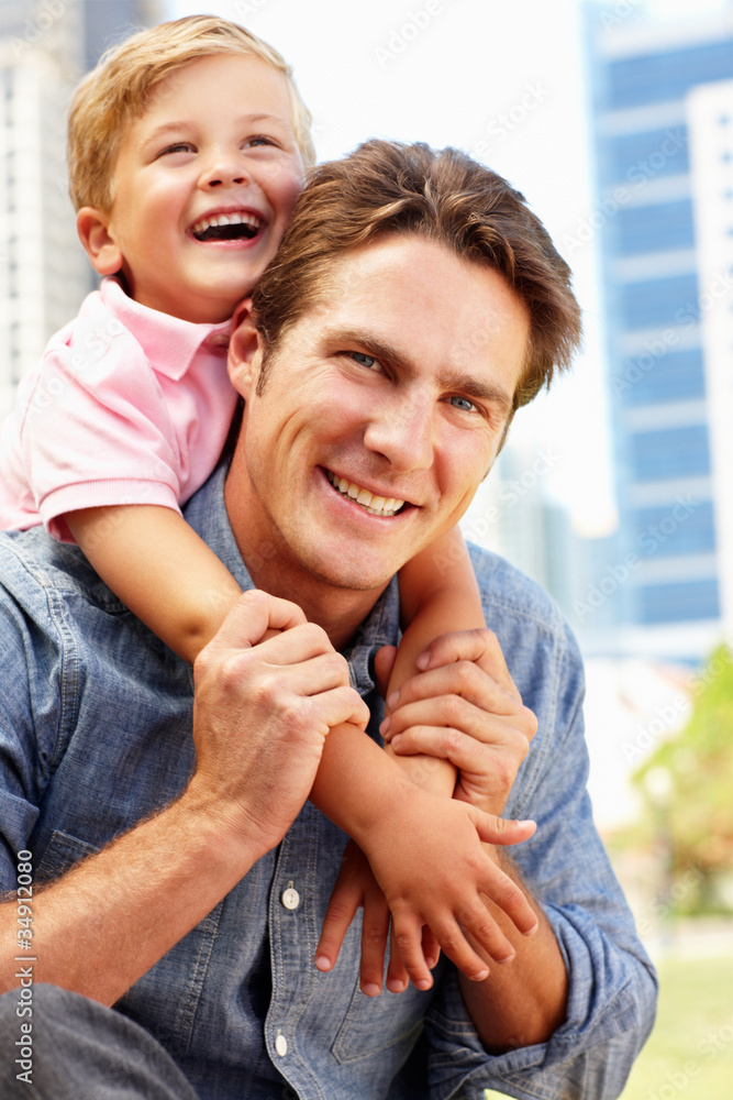 Fototapeta premium Man sitting in city park with young son