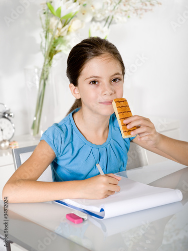 child eats snack while studying