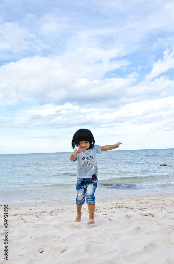 little asian girl running on the beach