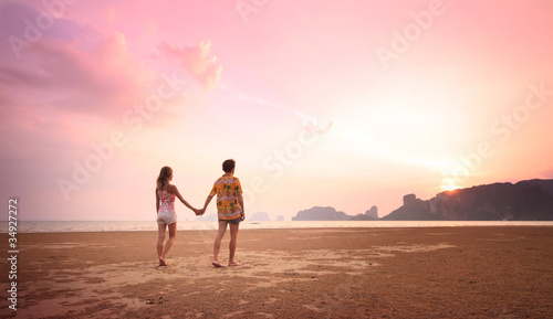 Young couple walking on a sandy coast © Dudarev Mikhail