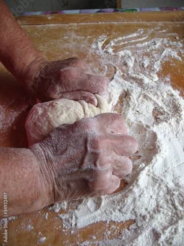 baker's hands knead dough