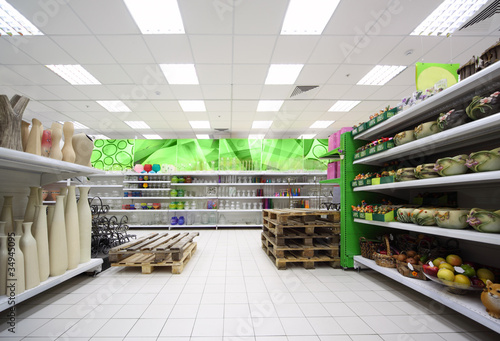 Shelves with colorful clay flowerpot, vases inside supermarket photo