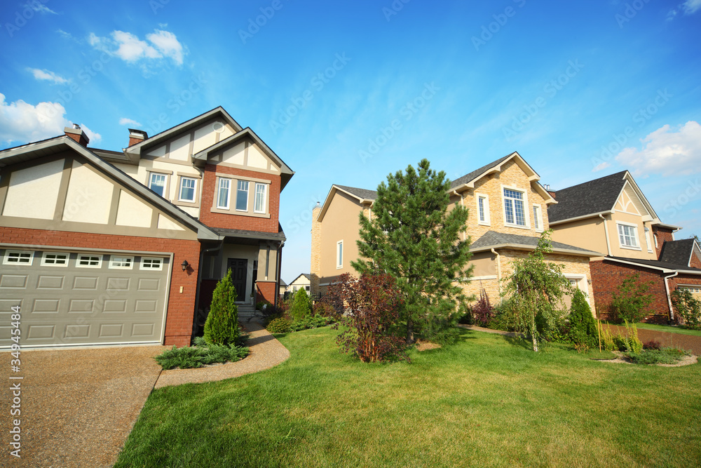 Green lawn with trees and shrubs between two brick houses Green lawn with trees and shrubs between two brick houses
