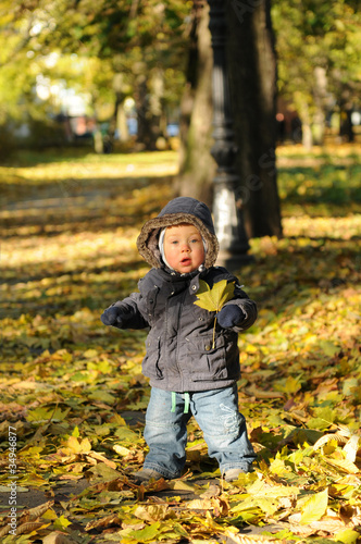 Toddler playing in the park in autumn