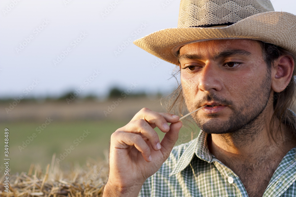 Fototapeta premium Farmer Thinking with Straw in His Mouth