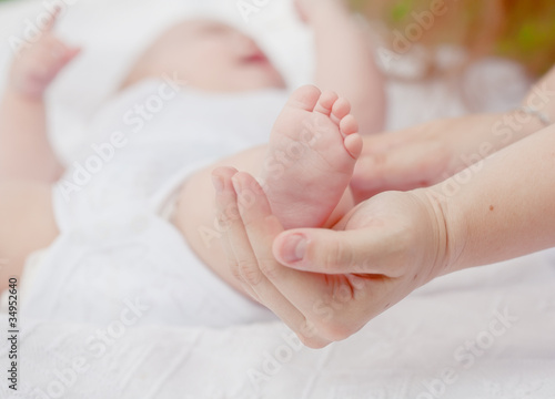 parental hand holds legs of the baby © Shchipkova Elena