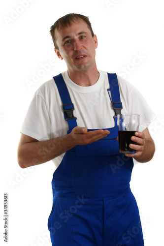 Handwerker mit blauer Latzhose hält ein Erfrischungsgetränk