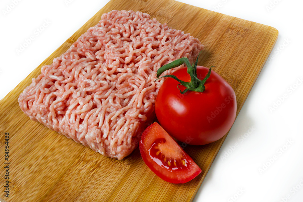 minced meat on a cutting board with tomato minced meat on a cutting board with tomato