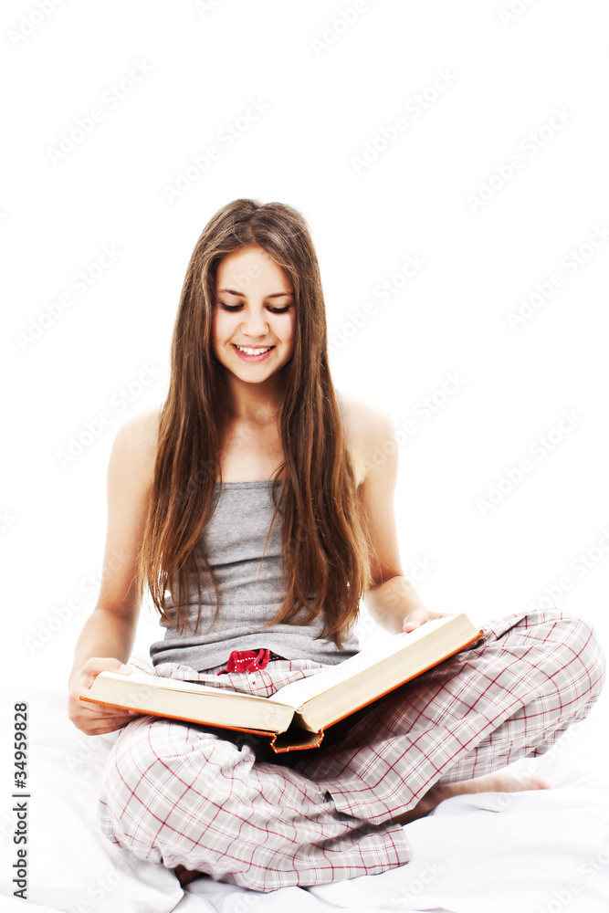 Young woman reading book in bed