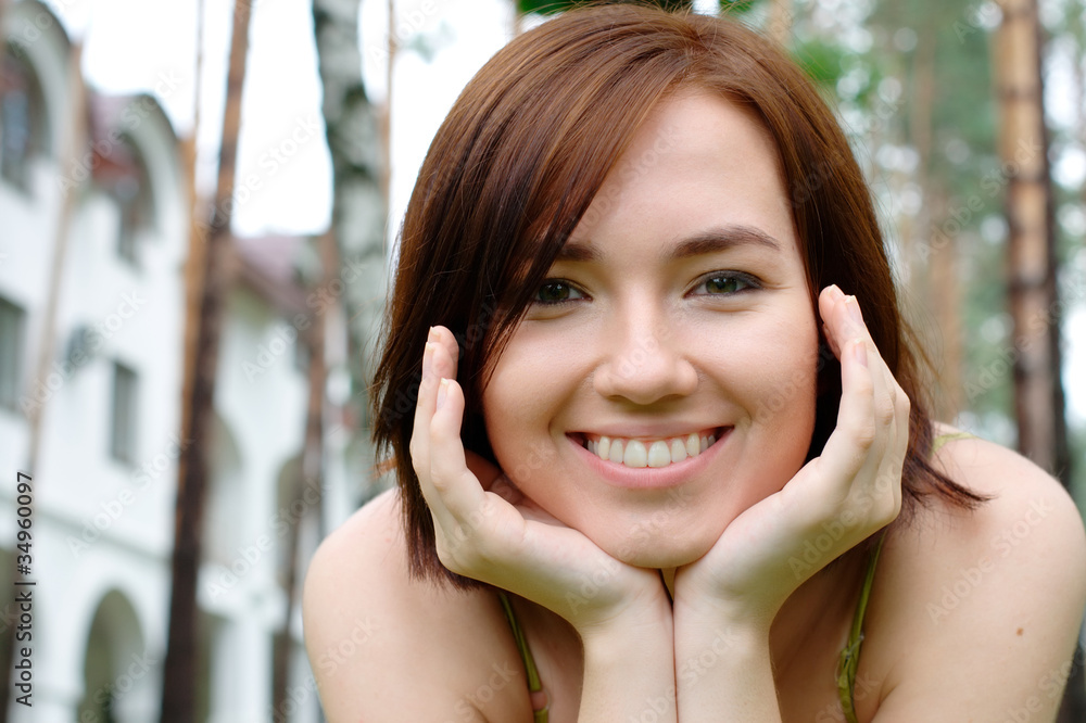 Smiling girl at the park with a house at the background Smiling girl at the park with a house at the background