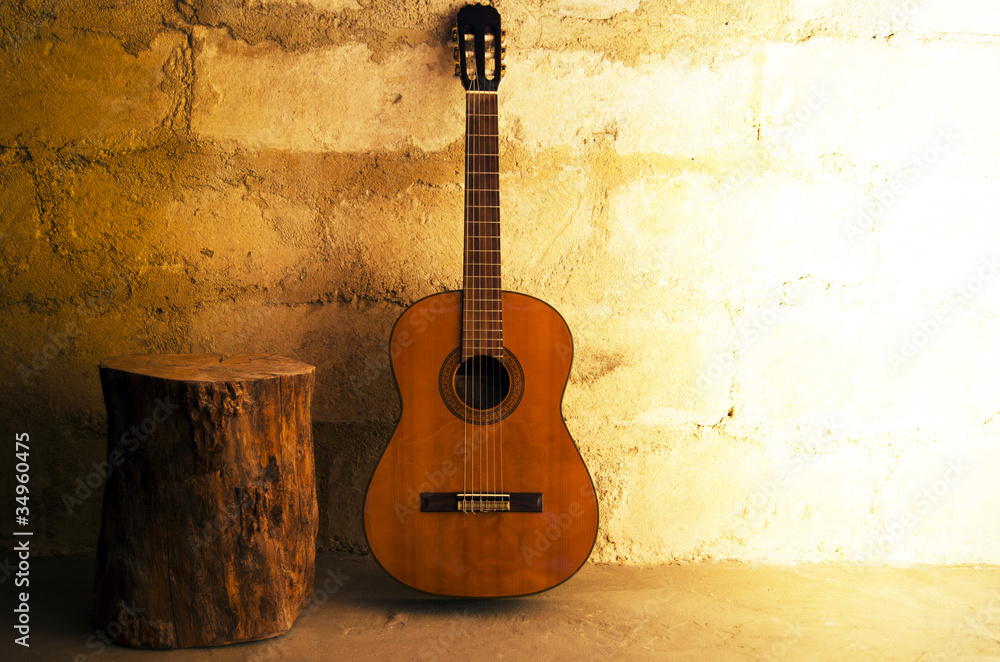 Naklejka premium Acoustic guitar on old wall - copyspace