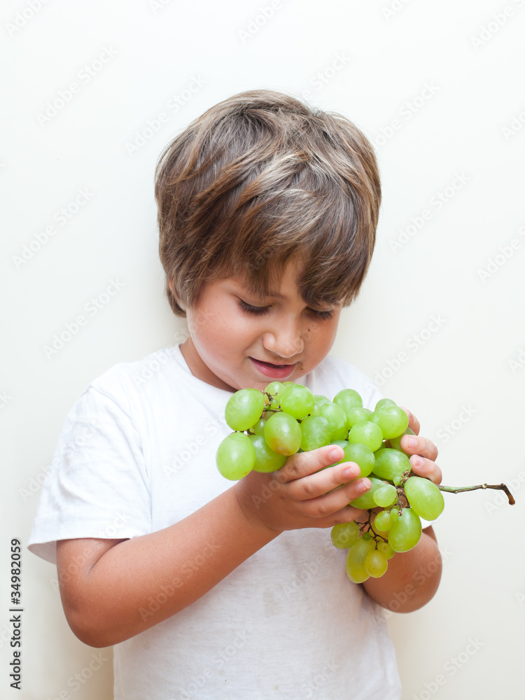 bambino con grappolo di uva in mano bambino con grappolo di uva in mano