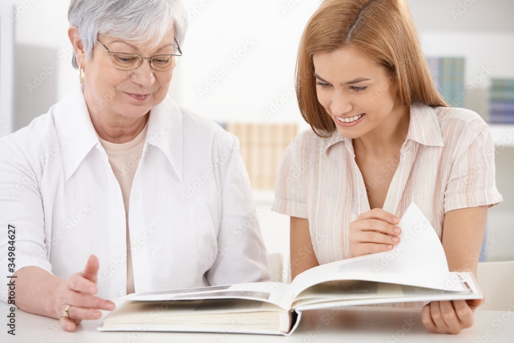 Senior mother and daughter looking at photo album Senior mother and daughter looking at photo album