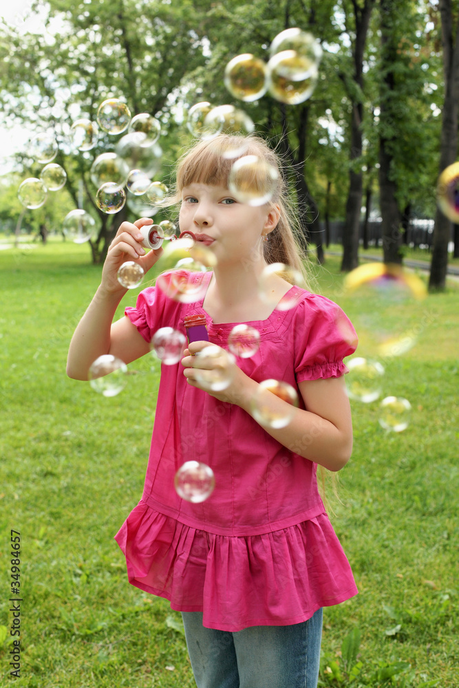 Little girl in the park blowing bubbles Little girl in the park blowing bubbles