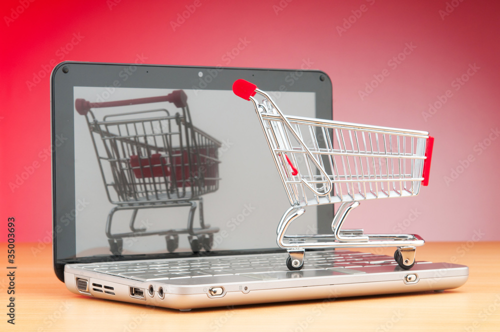 Shopping online with computer and cart Shopping online with computer and cart