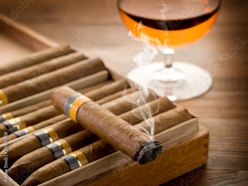 smoking cuban cigar and glass of  liquor on wood