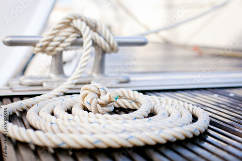 Mooring rope with a knotted end tied around a cleat.