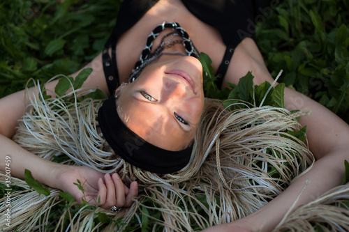 Young woman with braided lies on the grass
