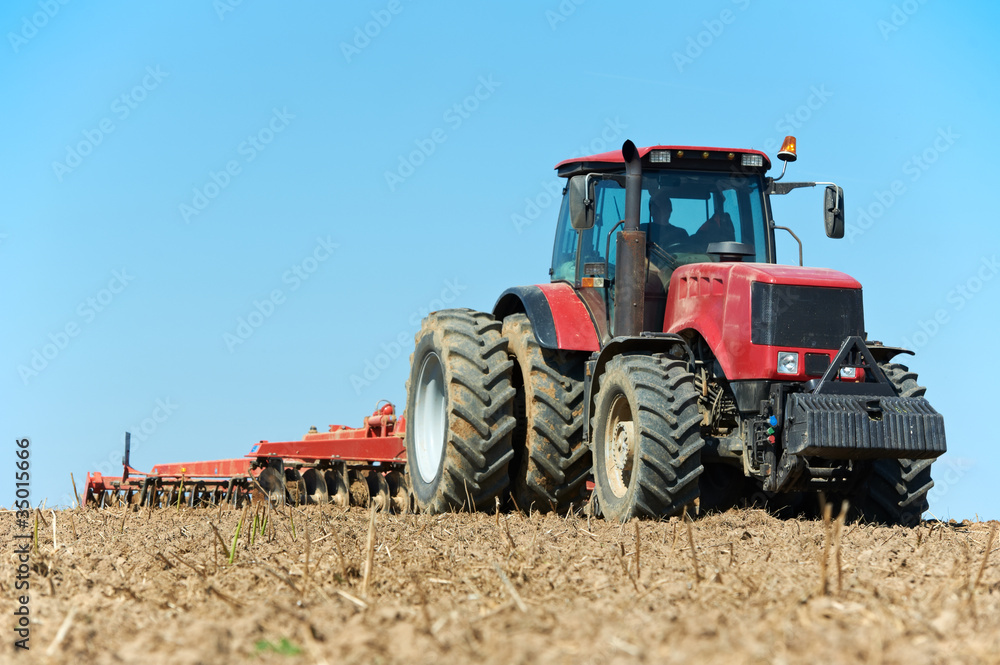 Ploughing tractor at field cultivation work Ploughing tractor at field cultivation work
