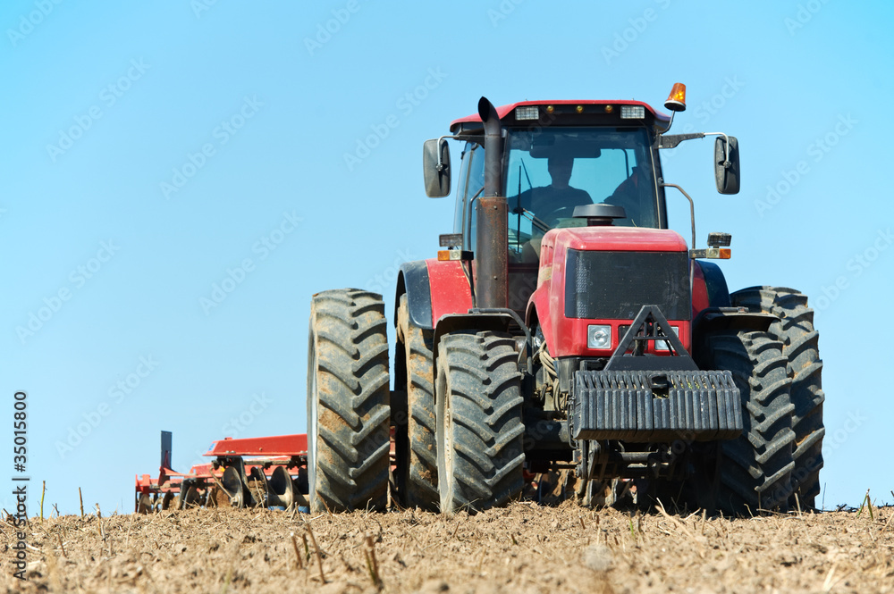 Ploughing tractor at field cultivation work Ploughing tractor at field cultivation work