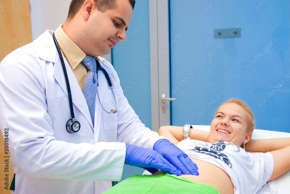Obraz premium Doctor examines a patient's belly