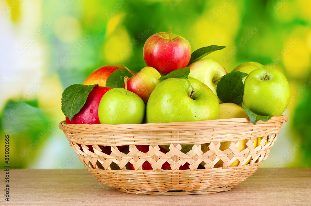 Fresh organic apples in basket on wooden table outside Fresh organic apples in basket on wooden table outside
