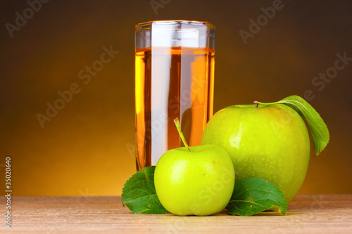Glass of healthy fresh juice of apples on brown background