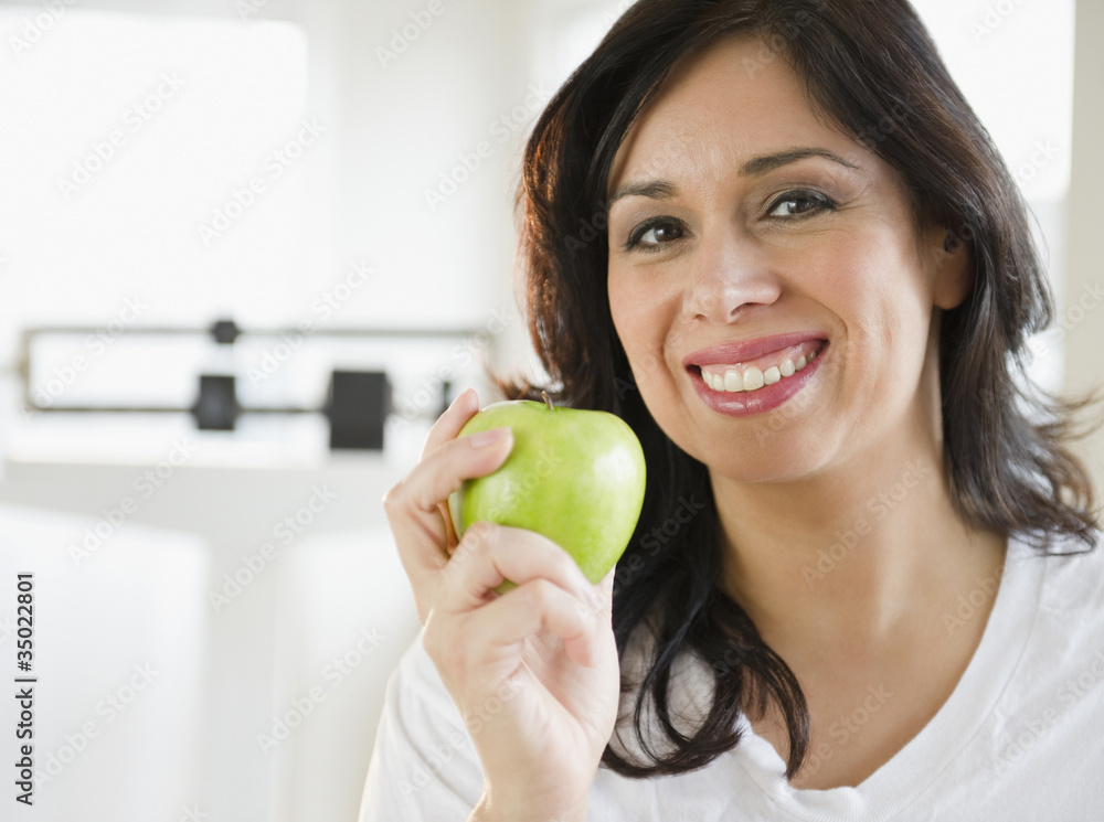 Smiling Hispanic woman holding a green apple Smiling Hispanic woman holding a green apple
